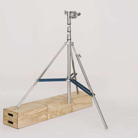 Heavy duty combo stand with 4-inch grip head for film rigging, displayed on wooden blocks.