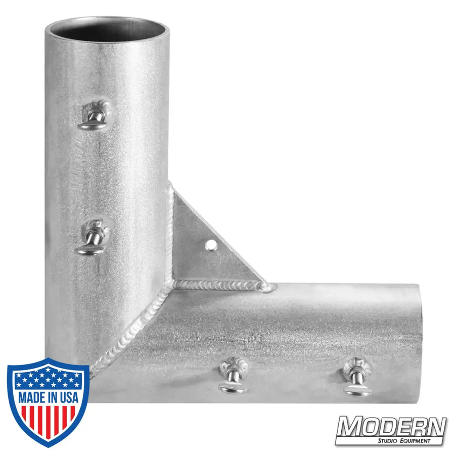 Welded aluminum corner fitting for 4-inch irrigation pipe, used in film grip rigging setups for creating 90º frame angles.