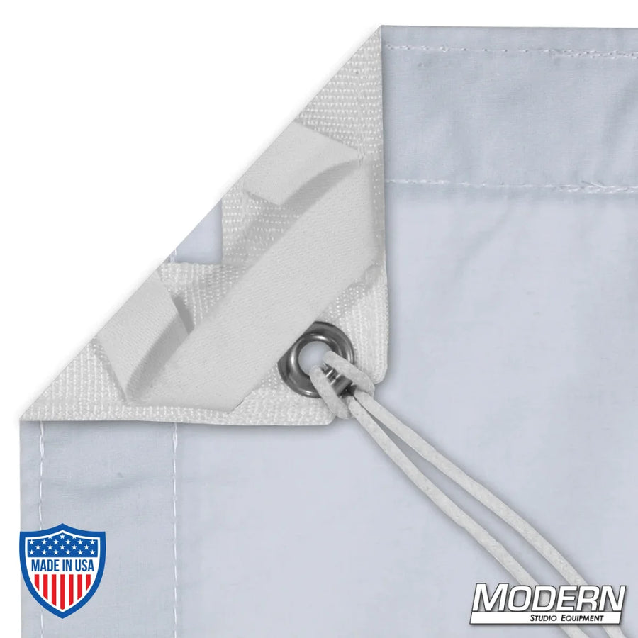 Close-up of Day Blue Muslin slip with elastic corners, grommets, and ties for film rigging, Modern Studio Equipment logo in the corner.