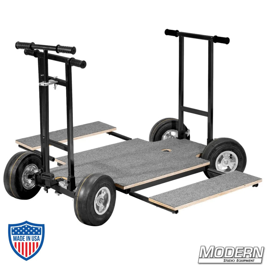 Doorway dolly with 4-way steering and black zinc finish, featuring a wood platform, push and pull bars, for film grip and rigging.