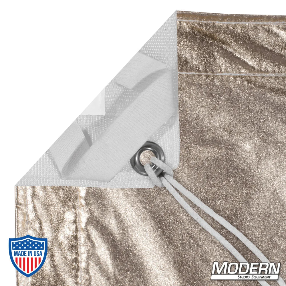 Corner of Gold/White Lame textile with grommet, ties, and elastic, designed for film grip and rigging, by Modern Studio Equipment.