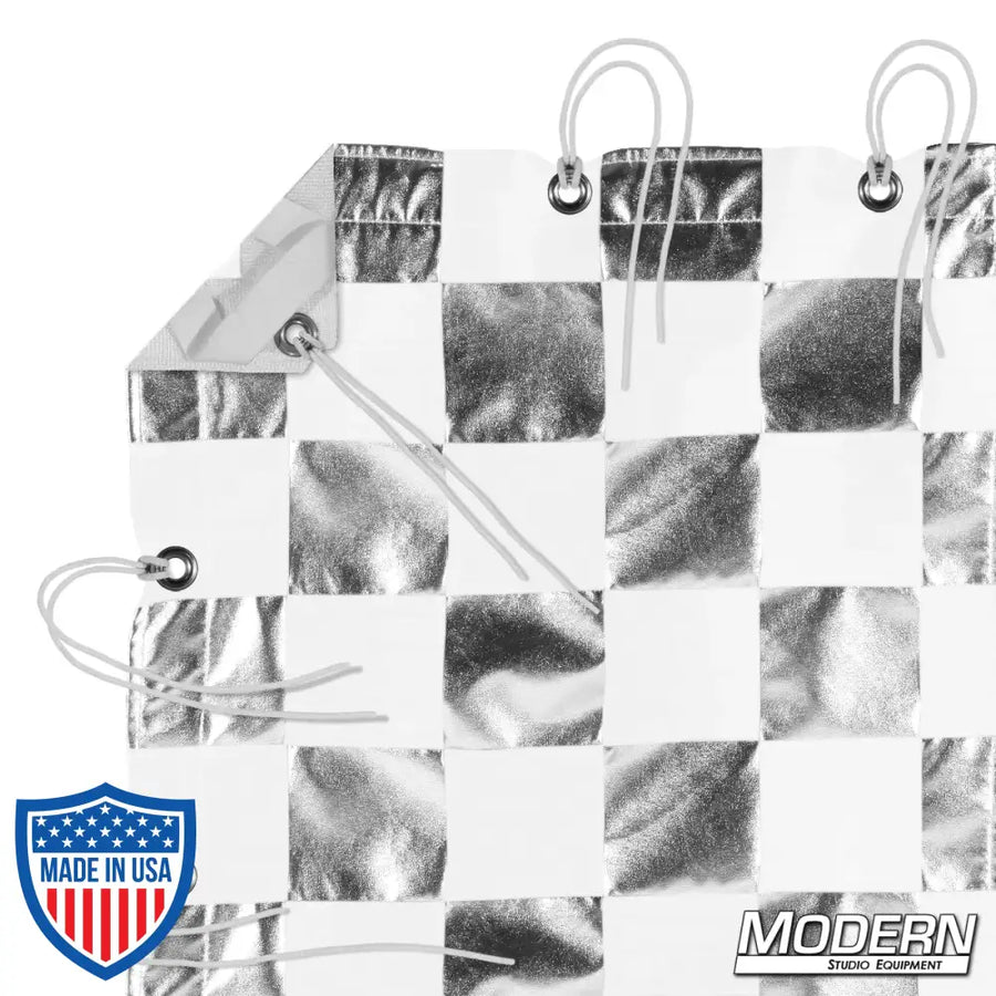 Silver and white checker pattern textile with webbing, grommets, ties, and elastic corners for film grip rigging, includes storage bag.