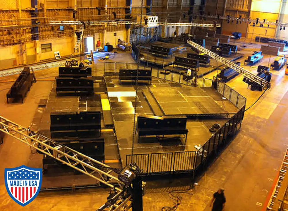 Steel deck platform setup in a large indoor film studio with rigging equipment and grip tools.
