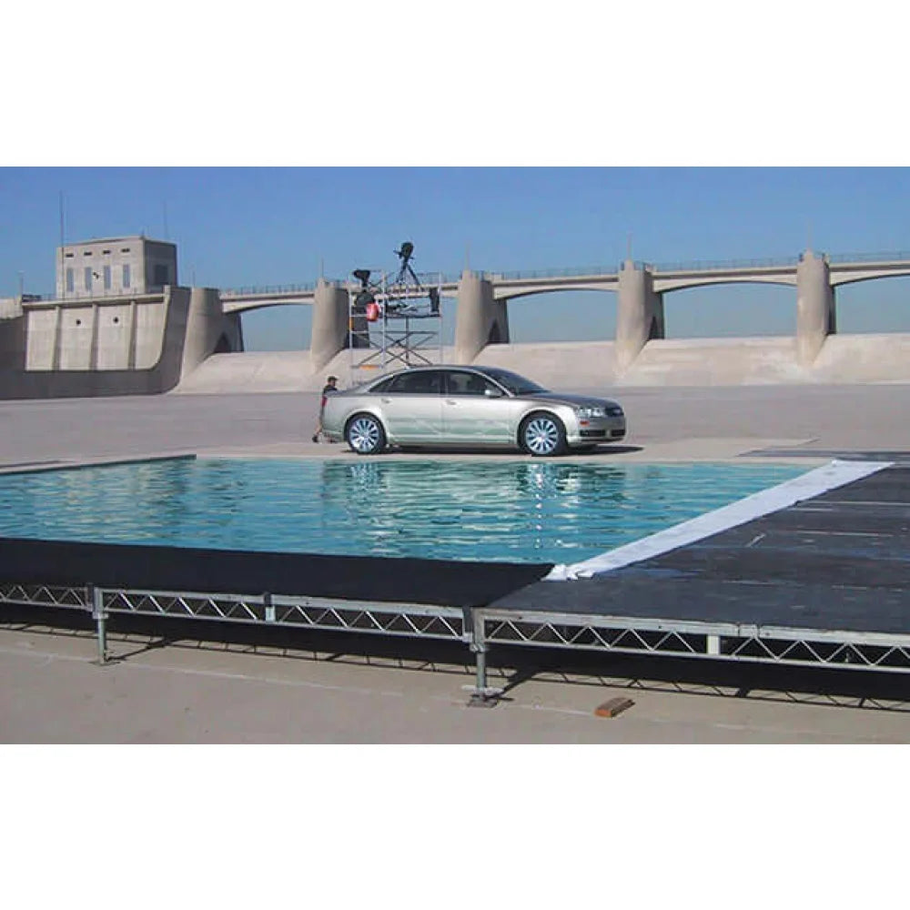Car on film set with steel deck rigging and water effect in outdoor location for grip and filming.