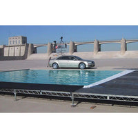 Car on film set with steel deck rigging and water effect in outdoor location for grip and filming.
