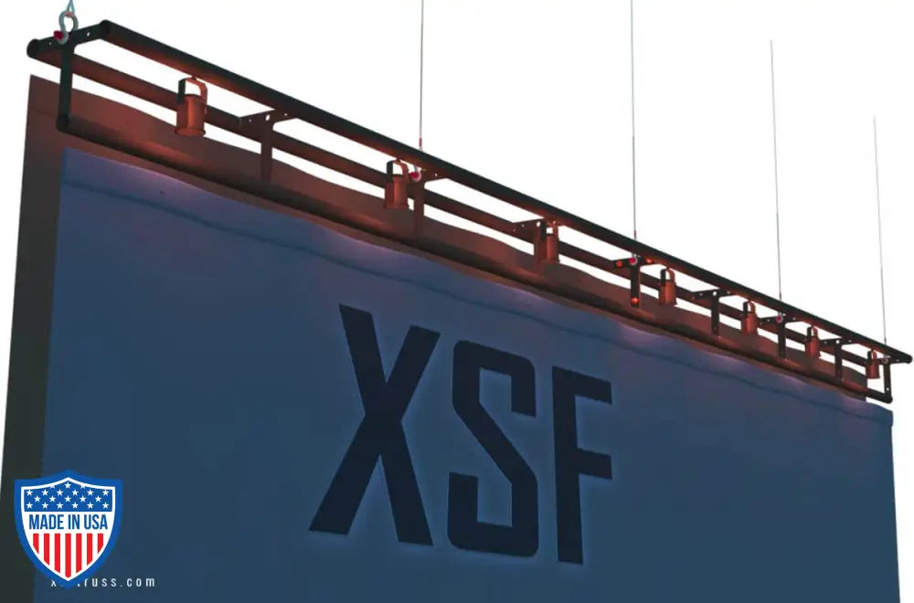 XSF 12-inch T-Batten Truss mounted above stage backdrop for grip and rigging in film and entertainment settings